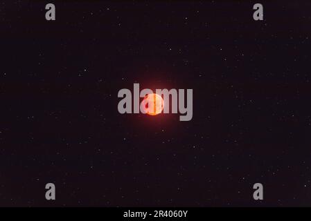Totally eclipsed moon in starfield, with the planet Uranus nearby Stock Photo