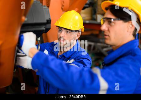 Maintenance engineers team working together at industrial factory Stock Photo