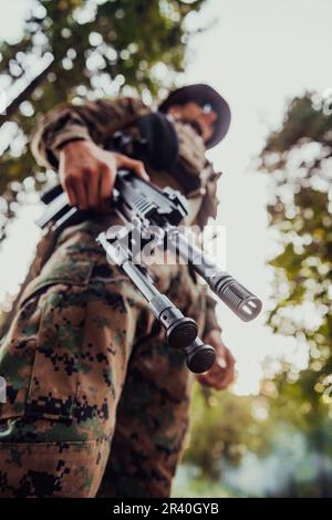 Soldier portrait with protective army tactical gear and weapon having a break and relaxing Stock Photo