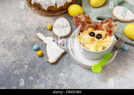 Easter breakfast idea. Scrambled eggs easter bunny on a stone background. Copy space. Stock Photo