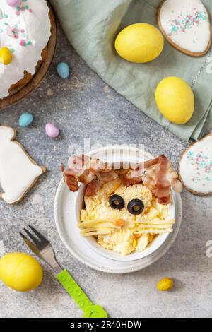Easter breakfast idea. Scrambled eggs easter bunny on a stone background. View from above. Stock Photo