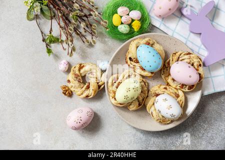 Easter composition. Sweet Italian Easter Bread Rings from puff pastry and dyed eggs on a stone background. View from above. Copy Stock Photo