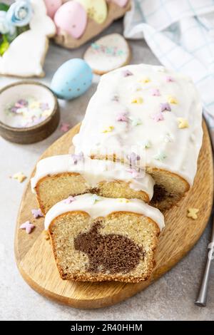 Happy Easter holiday food baking, cupcake with Easter Bunny and colorful eggs on stone background. Stock Photo