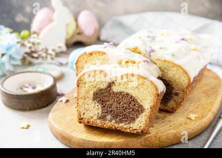 Happy Easter holiday food baking, cupcake with Easter Bunny and colorful eggs on stone background. Stock Photo