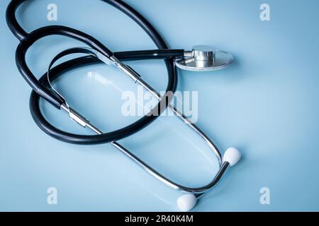 medical stethoscope lying on a pastel blue glass desk, Health, medicine and medical examination concept Stock Photo