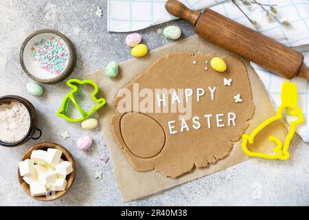Background for baking or cooking Easter cookies. Ingredients and kitchen utensils for baking on a light stone table. Stock Photo