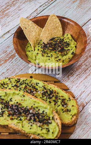 Dos tostas con guacamole y semillas acompañado de un bold con guacamole y semillas Stock Photo