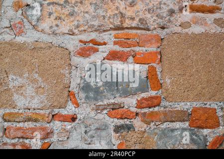 structure of the wall of an old house made of wild stone and brick, an idea for a background or framing space, Stock Photo