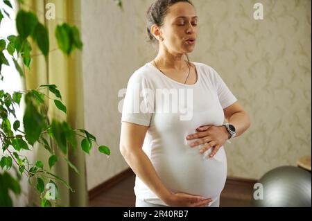 Pregnant woman putting on workout gloves in gym Stock Photo - Alamy