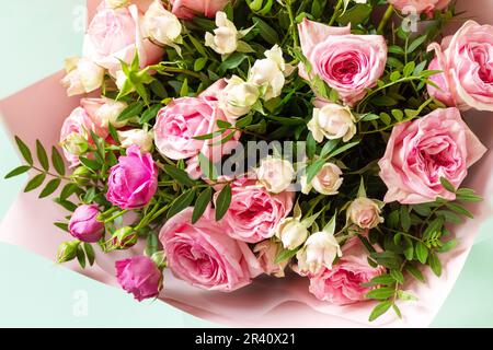 Mother's day, womens day or birthday card. Beautiful bouquet of blooming delicate pink roses and spring greenery on a green back Stock Photo
