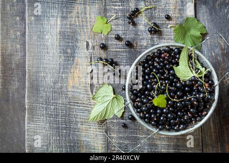 Raw organic berries. The concept of vitamin c food. Fresh black currants on a wooden table in rustic style. View from above. Cop Stock Photo