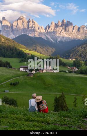Couple viewing the landscape of Santa Maddalena Village in Dolomites Italy Stock Photo