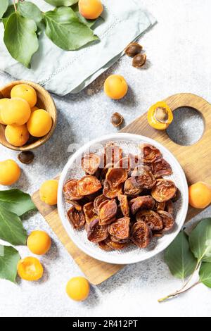 Dried fruits. Dried apricots and raw apricots on a gray stone background. View from above. Stock Photo
