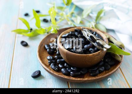 Raw organic vegetables. The concept of vegan or diet food. Fresh ripe black soy beans on a wooden table. Stock Photo