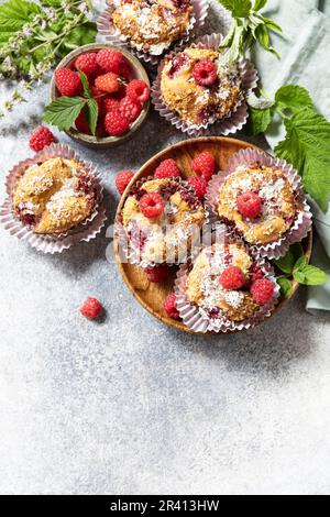 Healthy dessert. Vegan gluten-free pastry. Oatmeal banana muffins with raspberry and coconut flakes on a stone table. View from Stock Photo