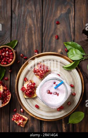 Vegan protein smoothie made from pomegranate and banana on a rustic wooden table. Healthy food, healthy lifestyle. Foodism, raw Stock Photo