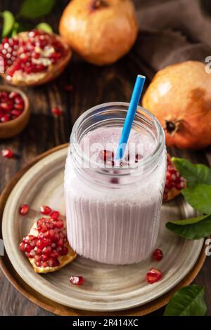 Vegan protein smoothie made from pomegranate and banana on a rustic wooden table. Healthy food, healthy lifestyle. Foodism, raw Stock Photo