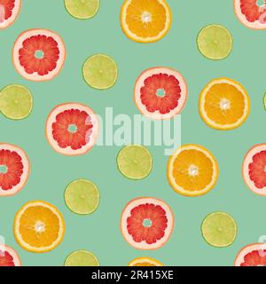 Sliced pieces of orange, lime and grapefruit on a green background Stock Photo