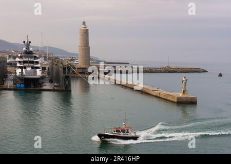 Pilot boat guiding a cruise ship into the Port of Livorno, Italy, with it's lighthouse and statue of the Virgin at the entrance. Stock Photo