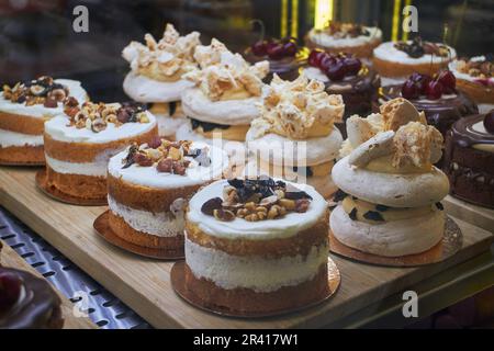 Bento cakes and other desserts with various flavors and decorations in display case for sale in the market. Fashion sweetness. Stock Photo