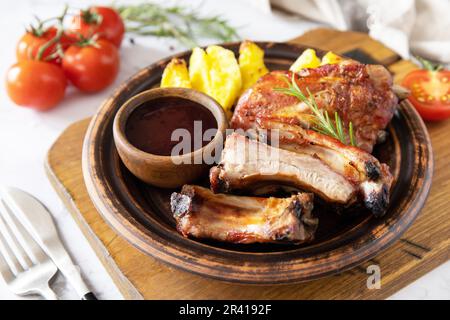 BBQ grilled veal calf brisket meat and french fries potatoes with sauce on a marble tabletop. Stock Photo