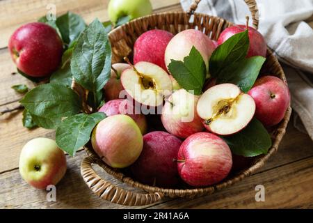 Fall harvest background. Organic fruits. Farmer's market. Basket of ripe apples on a rustic wooden table. Stock Photo