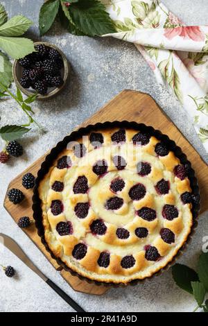 Vegan gluten-free pastry. Homemade blackberry pie. Sweet pie with blackberry and custard on stone tabletop. Stock Photo