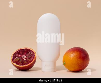 White plastic tube for liquid cosmetics on a beige background, packaging Stock Photo