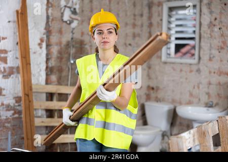 Female carrying wooden panel on construction site Stock Photo