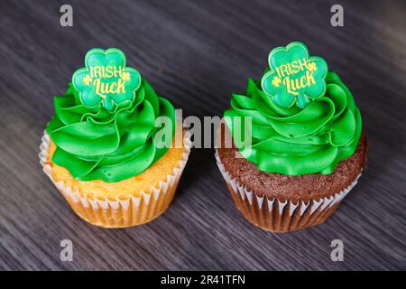 Vanilla and chocolate St. Patrick’s Day cupcakes green frosting Irish Luck four-leaf clover topper Stock Photo