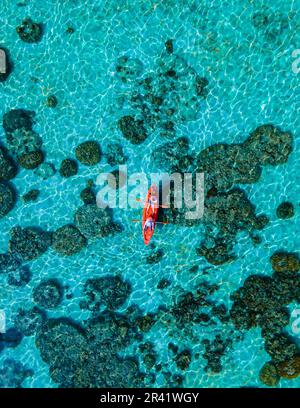 Couple with a kayak on a small Island in front of the Island Ko Lipe Thailand Stock Photo