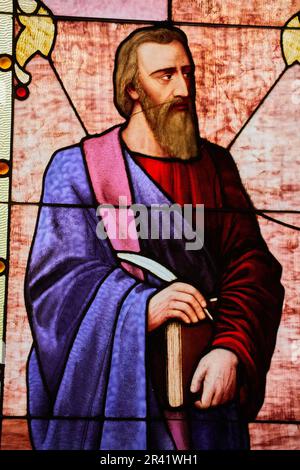 Mark, John, Luke, or Mathew apostle saint holding Christian bible book and quill church window Stock Photo