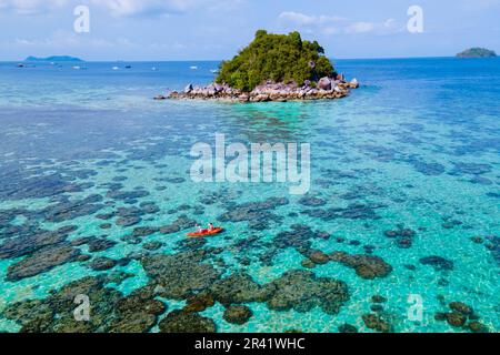 Couple with a kayak on a small Island in front of the Island Ko Lipe Thailand Stock Photo