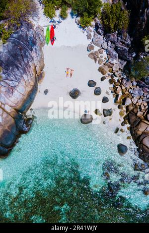 Couple with a kayak on a small Island in front of the Island Ko Lipe Thailand Stock Photo