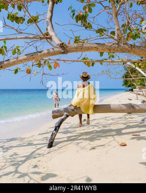 A couple of men and woman on the beach of Koh Kradan Island Thailand Stock Photo