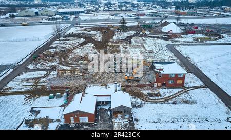 Construction site with tire tracks through snow and debris from destroyed buildings Stock Photo