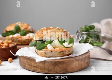 Delicious sandwich with hummus, microgreens and cucumber slices on white wooden table Stock Photo