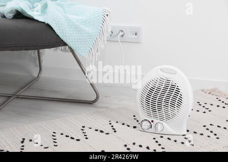 Electric fan heater on floor at home. Space for text Stock Photo