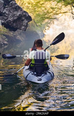 A young couple enjoying an idyllic kayak ride in the middle of a ...