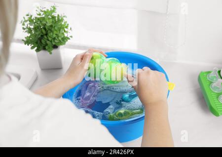 Woman washing baby bottle nipples under stream of water, above view Stock  Photo - Alamy
