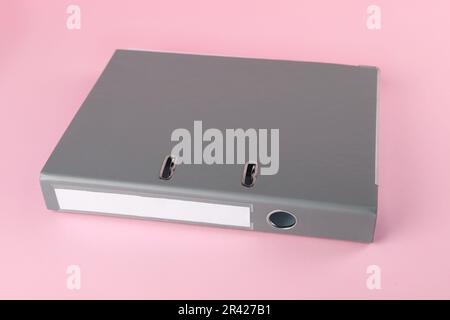 Grey hardcover office folder on pink background Stock Photo