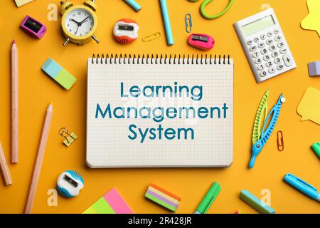Notebook with text Learning Management System and stationery on yellow background, flat lay Stock Photo