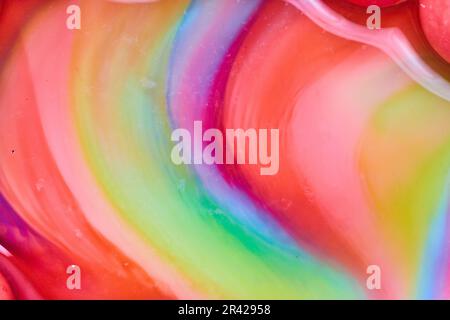 Abstract heart curved swirl of candy colors as skittles sugar mixes with water in background asset Stock Photo