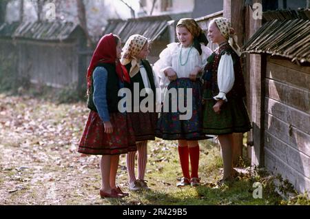 Maramures, Romania, approx. 1976. Local girls on the village lane wearing their traditional folk costumes. Stock Photo
