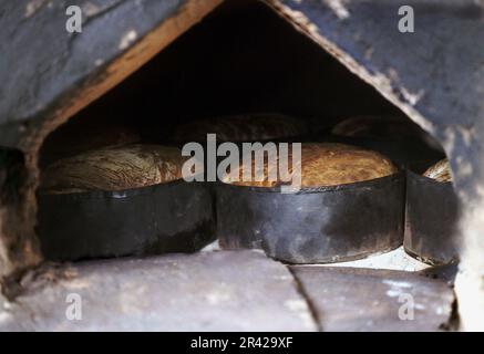 Salaj County, Romania, 1999. Baking loaves of bread in traditional clay oven. Stock Photo