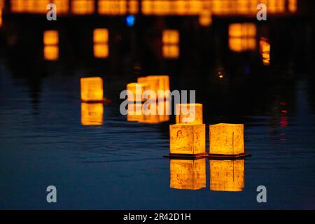 Calm deep dark blue pond with golden lanterns Stock Photo