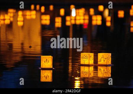 Golden lanterns floating on water at festival Stock Photo
