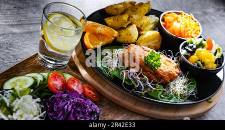 Pulled chicken cutlet coated with breadcrumbs with potatoes and vegetable salads Stock Photo