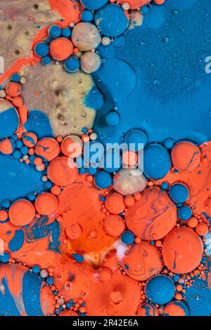 Vertical background asset painting with abstract pour of blue orange and golden oily pearls Stock Photo