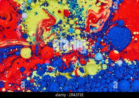 Painting of galactic swirling of blue red yellow and white acrylic painted bubbles with oil background asset Stock Photo